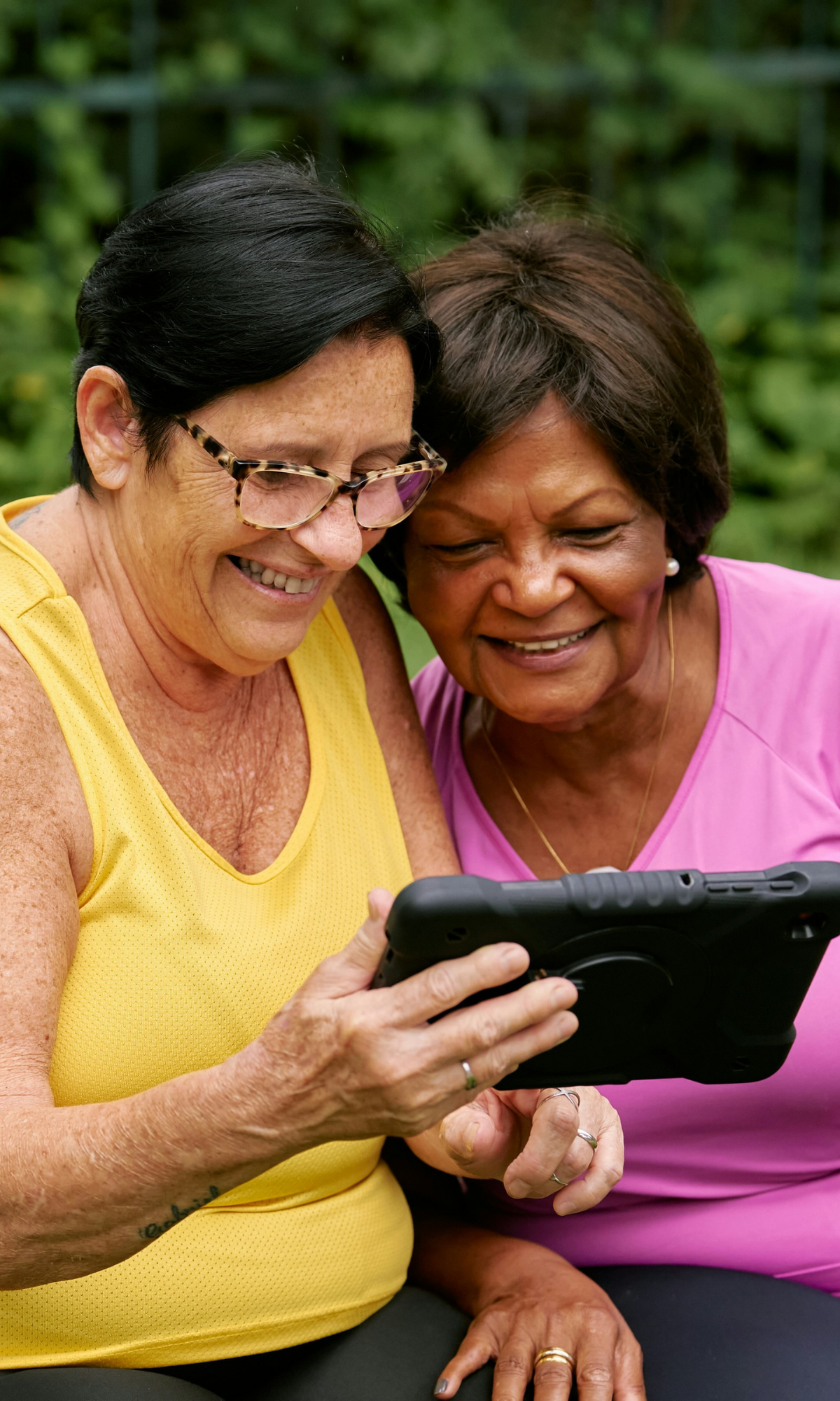Two women looking at iPad screen and smiling