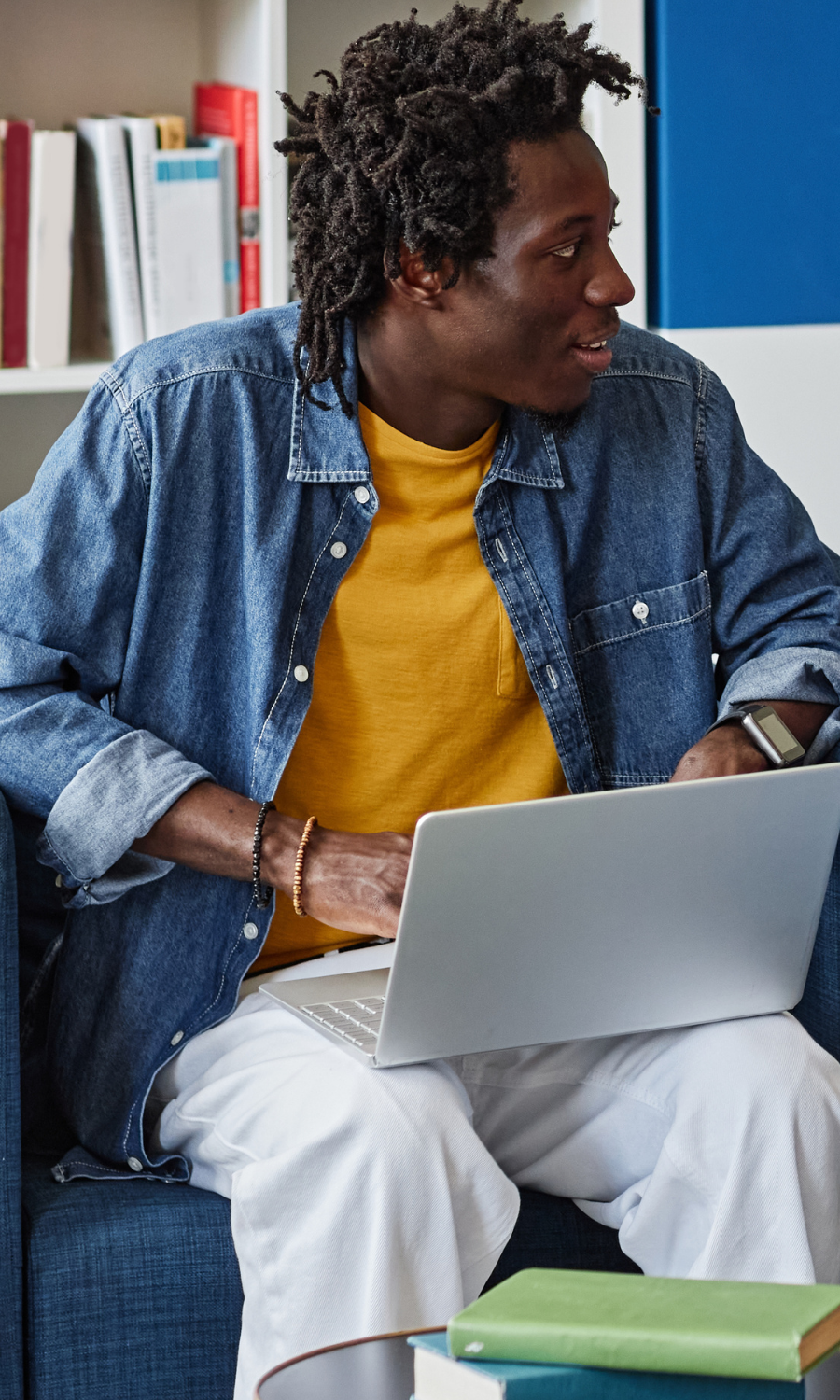 man sitting and chatting with someone looking at a laptop
