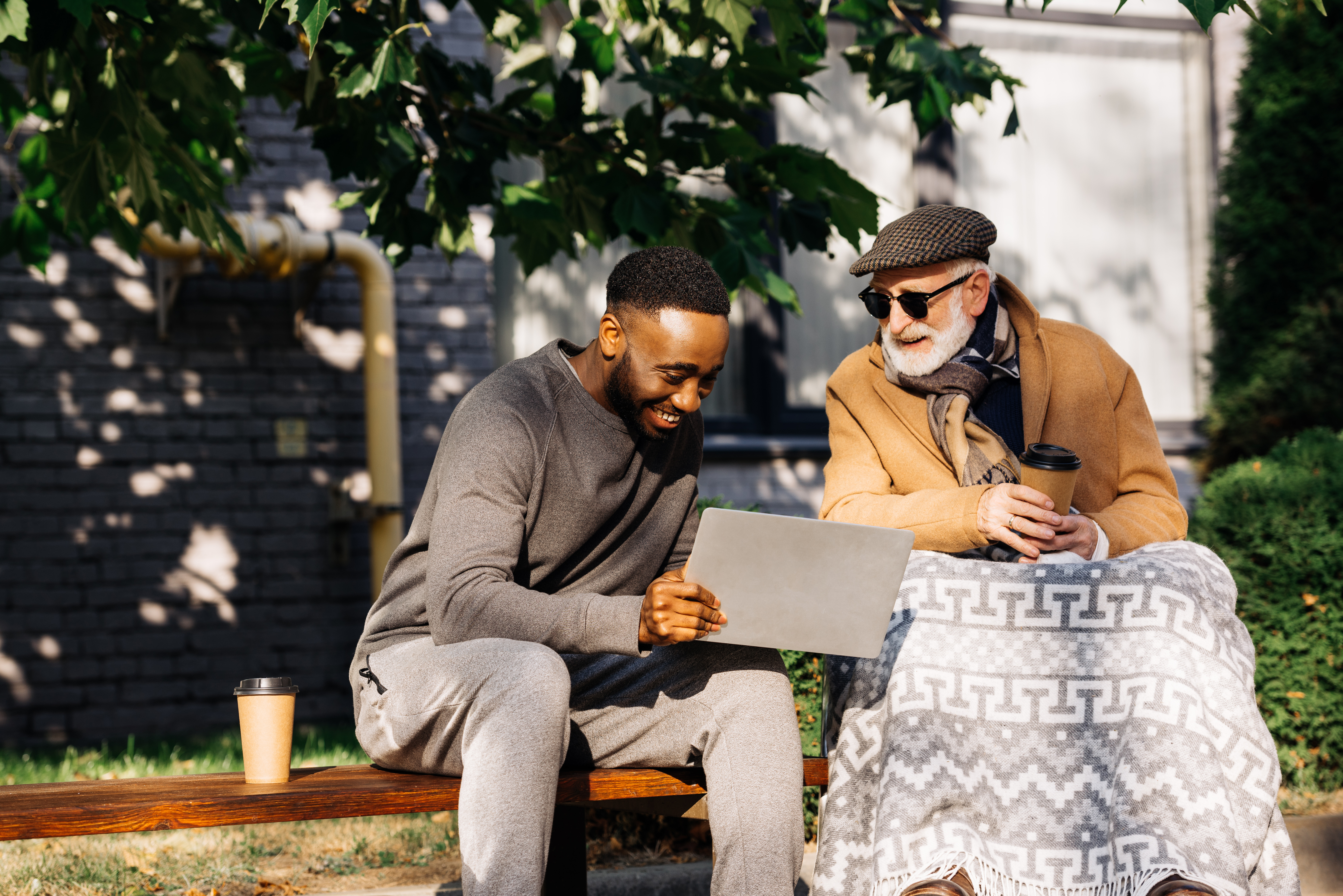 Service user and support worker laughing at something on a laptop