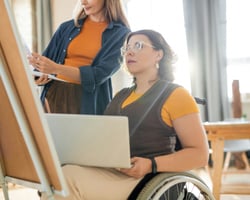 support worker helping a person paint-1